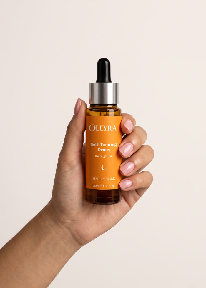 A bottle of Oleyra Overnight Tanning Drops held in one hand