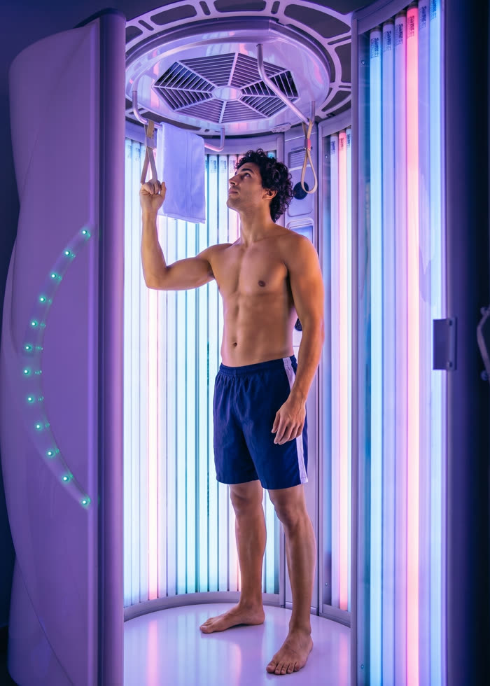 A person standing in a UV tanning booth